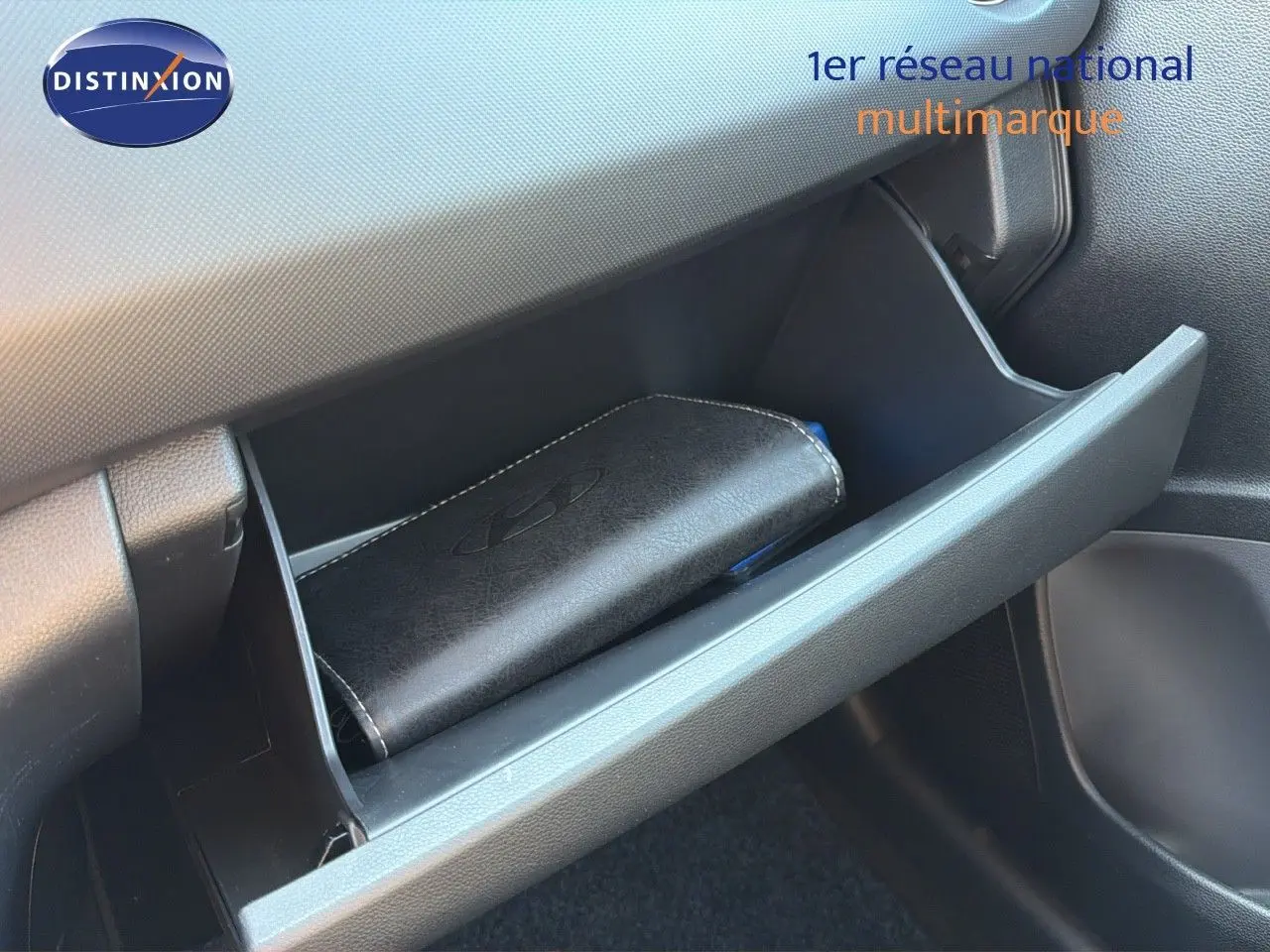 Gant de rangement ouvert côté passager d'une Hyundai i10 blanche 2018 avec manuel dans la boîte à gants.