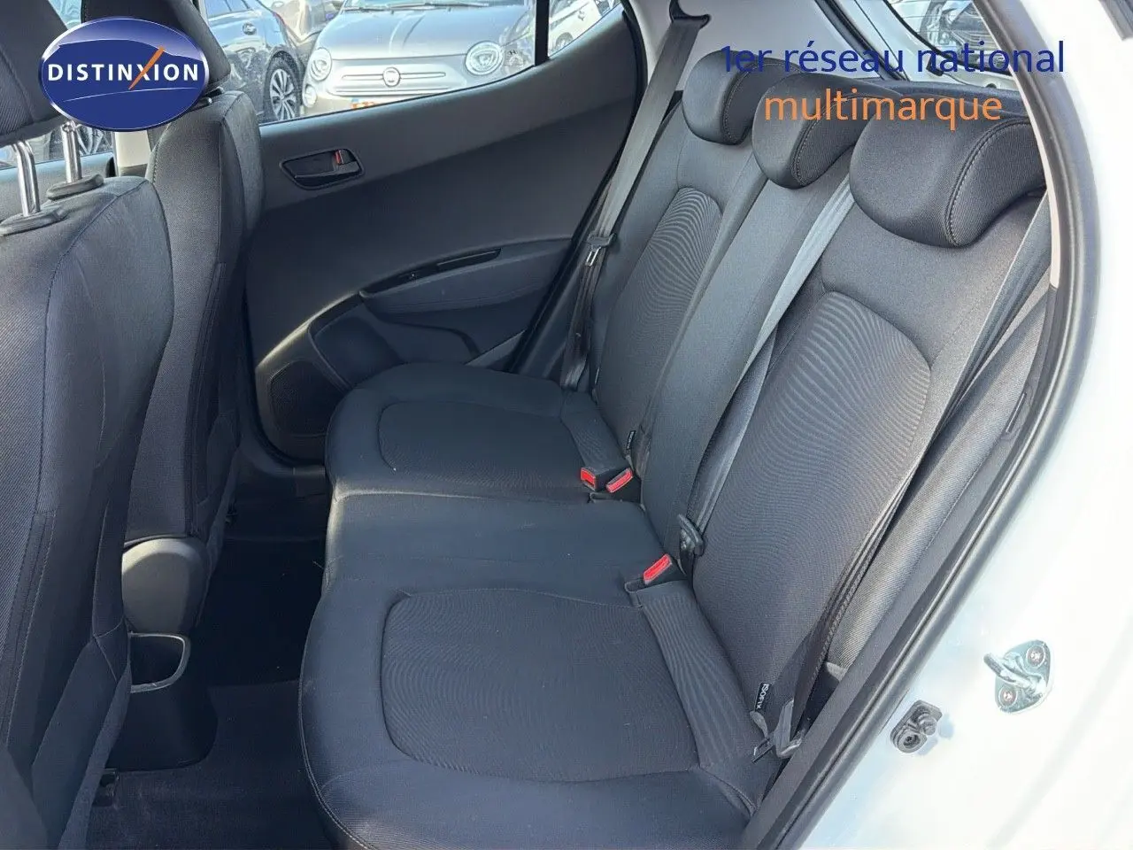 Vue intérieure côté droit sur les sièges arrière noirs d'une Hyundai i10 blanche 2018, porte ouverte.