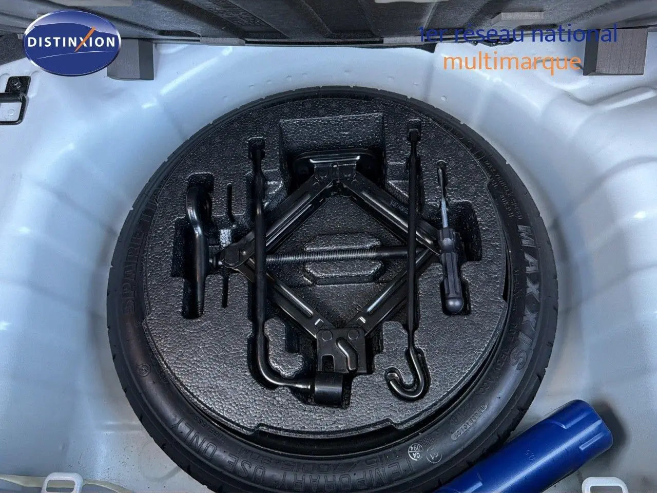 Vue plongeante sur la roue de secours et les outils de bord dans le coffre d'une Hyundai i10 blanche 2018