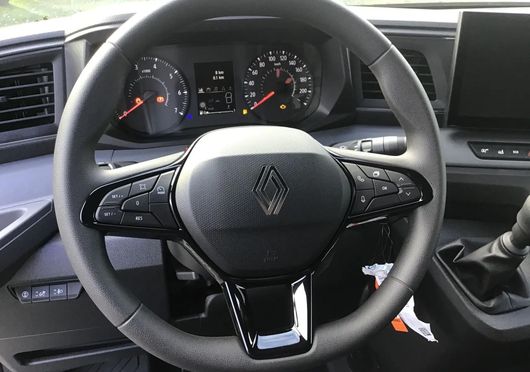 Vue rapprochée du volant multifonction noir du Renault Master L3H2 2025 avec tableau de bord et levier de vitesse manuel.