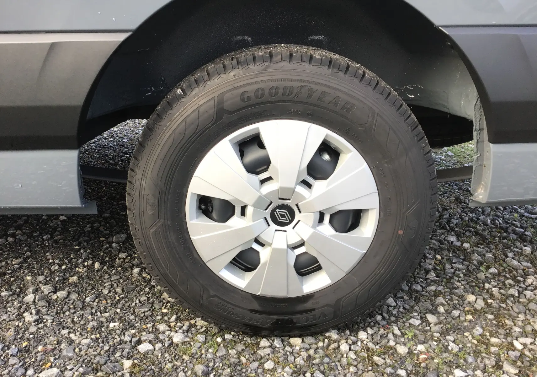 Gros plan sur la roue avant droite du Renault Master gris urbain avec pneu Goodyear tout-temps et jante argentée.