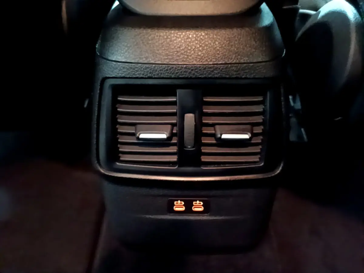 Gros plan sur les aérateurs arrière et commandes de chauffage des sièges du BMW Série 2 Gran Tourer gris clair 218d Lounge.