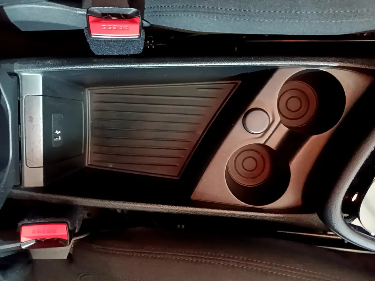 Vue plongeante sur la console centrale noire avec porte-gobelets et bouton USB de la BMW Série 2 Gran Tourer 218d Lounge.