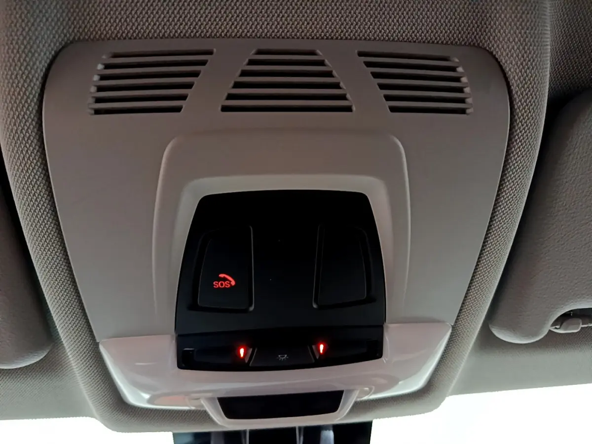 Vue intérieure du plafonnier avec bouton SOS et commandes d’éclairage, dans une BMW Série 2 Gran Tourer gris clair.