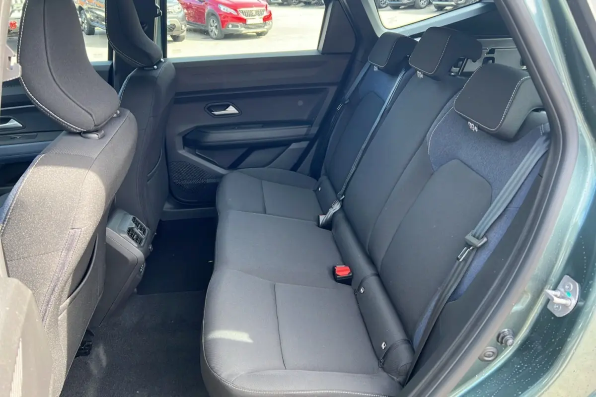 Vue côté gauche de l'intérieur arrière du Dacia Bigster vert cèdre, montrant la banquette 3 places avec appuie-têtes.