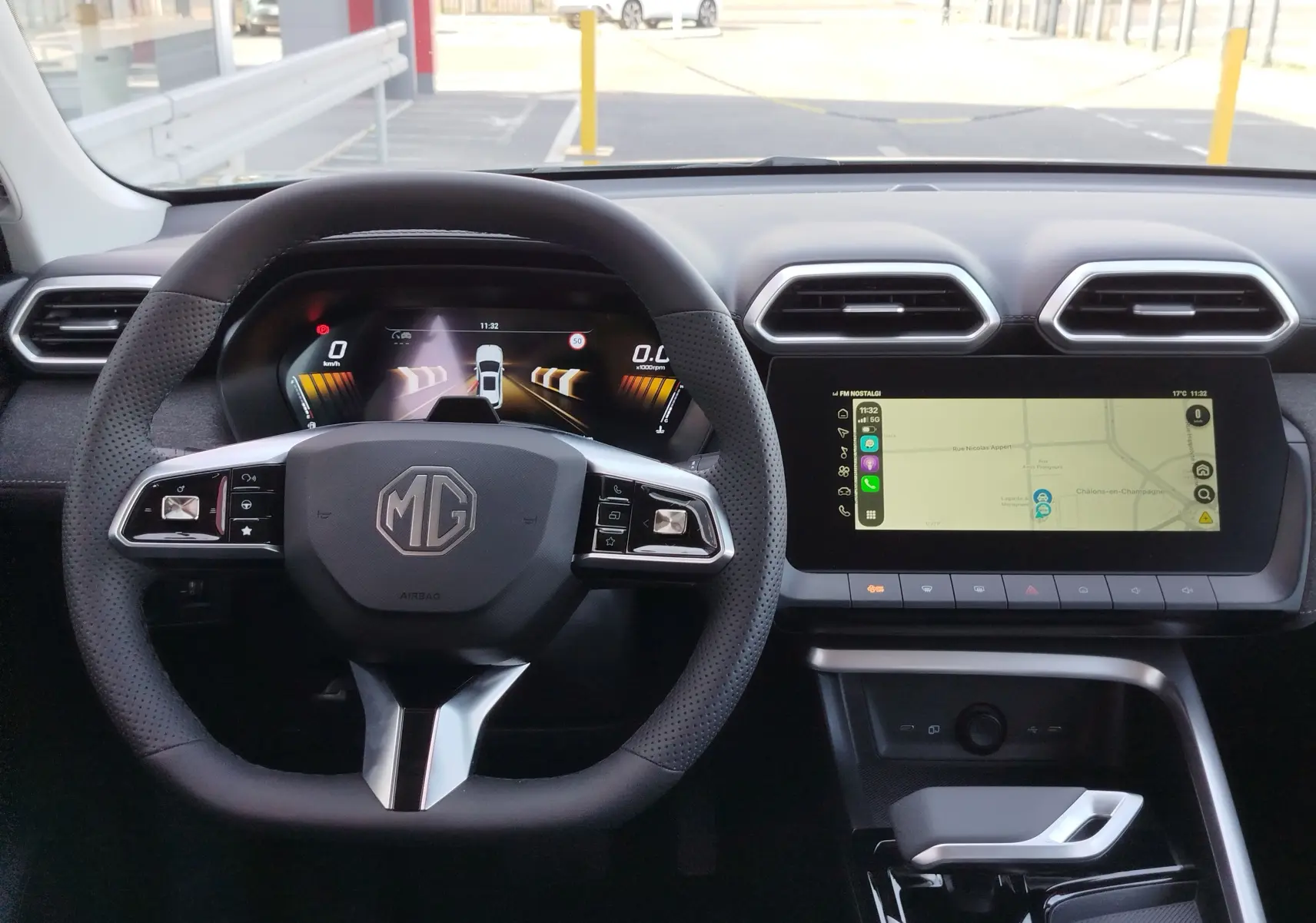 Vue intérieure du tableau de bord MG ZS 2026, volant multifonction noir et écran tactile avec navigation affichée.