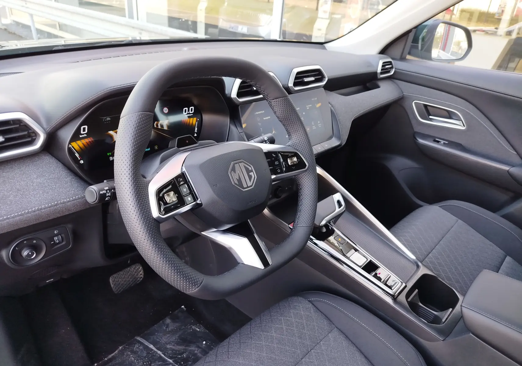 Vue intérieure côté conducteur du MG ZS 1.5L Hybrid+ 2026, tableau de bord noir avec volant multifonction et écran tactile.