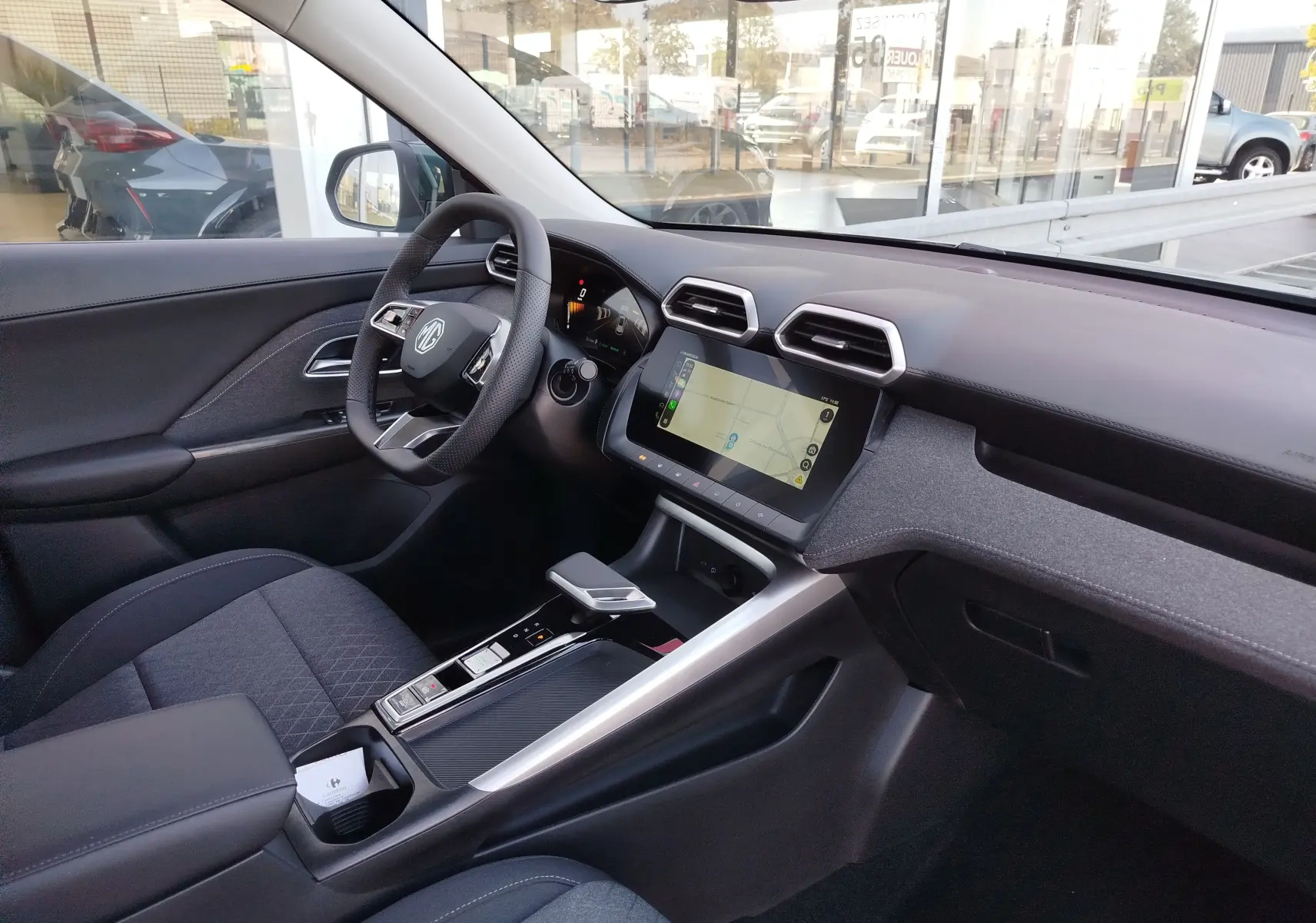 Intérieur noir du MG MOTOR ZS 1.5L Hybrid+ 2026 vu côté conducteur, avec écran tactile et volant multifonction.