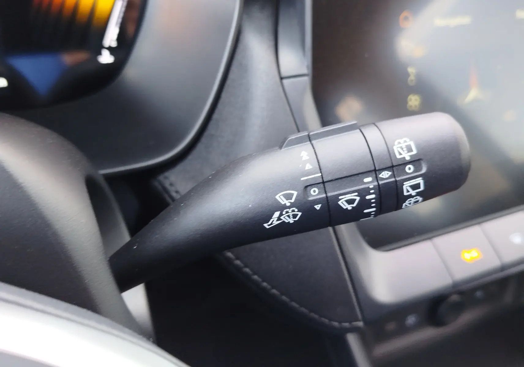 Gros plan sur la commande des essuie-glaces à gauche du volant dans l'habitacle noir du MG Motor ZS hybride 2026.