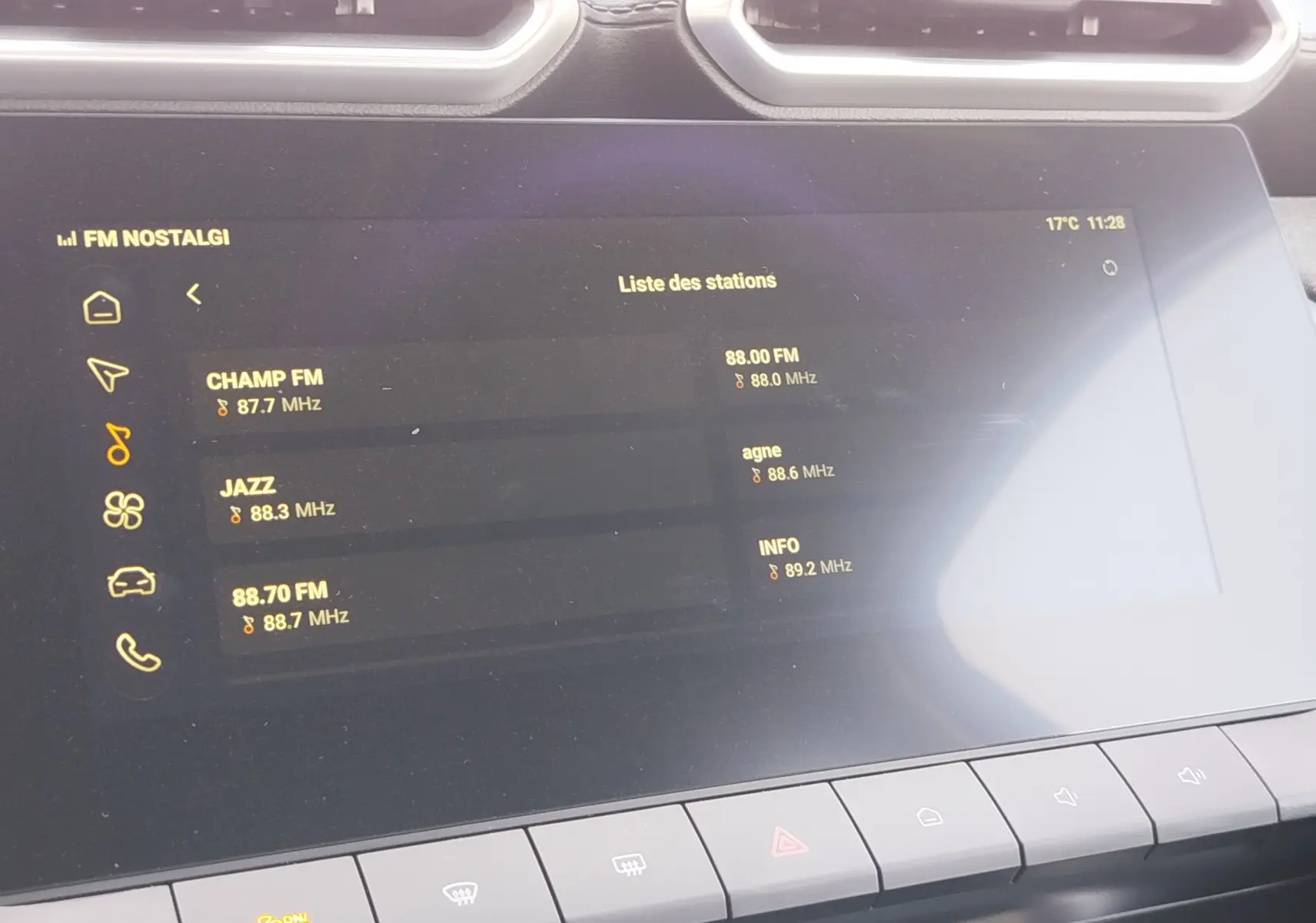 Écran tactile central du MG ZS 2026 affichant la liste des stations radio, avec commandes climatisation en bas.