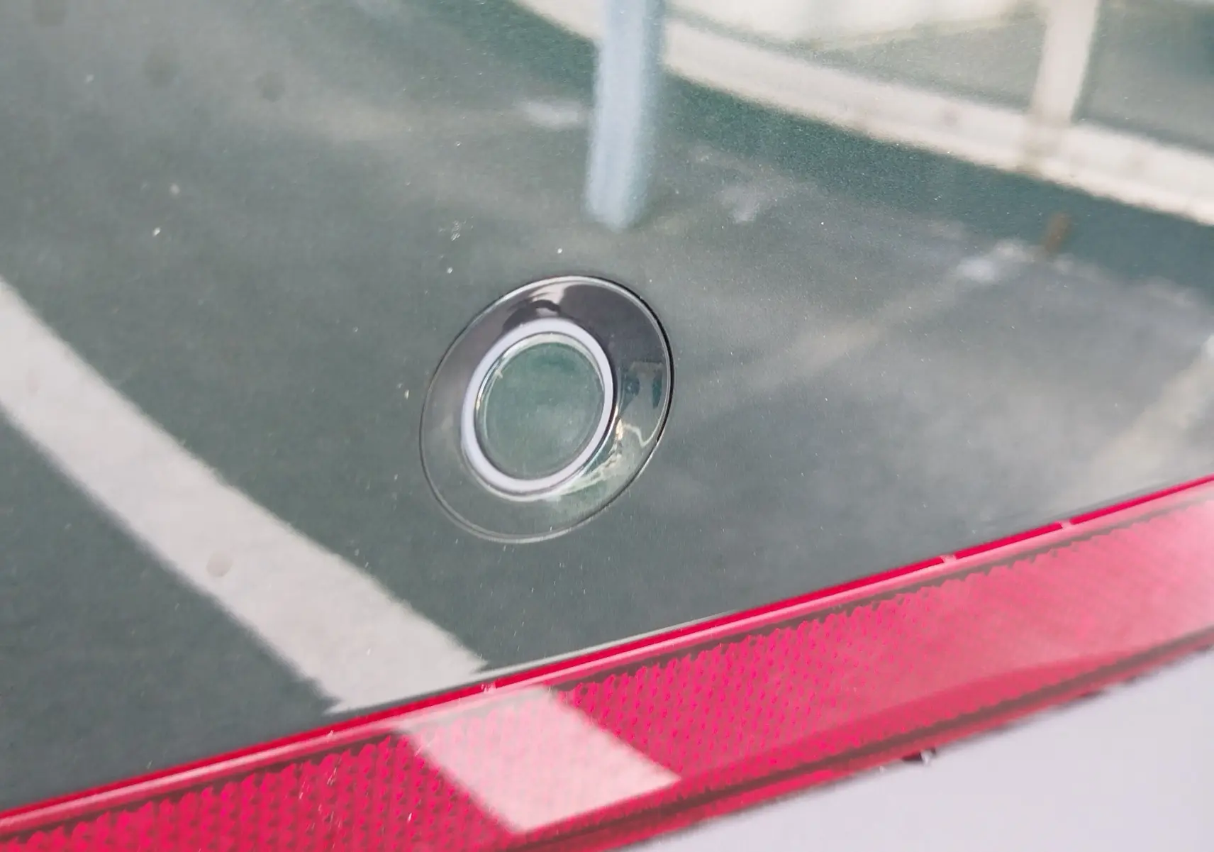 Détail du capteur de stationnement arrière sur la carrosserie vert émeraude d’un MG MOTOR ZS 2026.