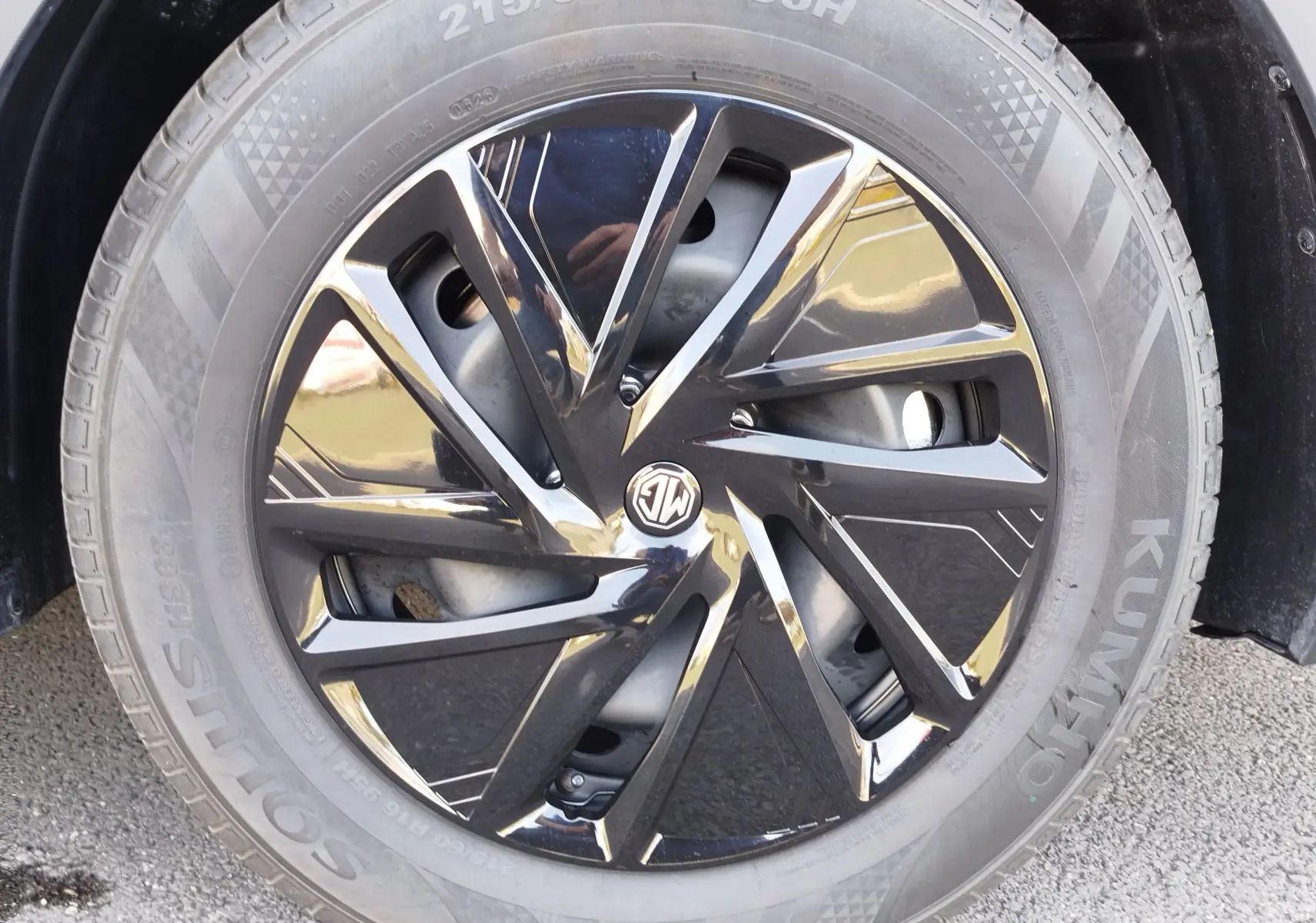 Gros plan sur la jante noire brillante au design géométrique du MG MOTOR ZS 1.5L HYBRID+ 197CH, roue avec pneu Kumho.