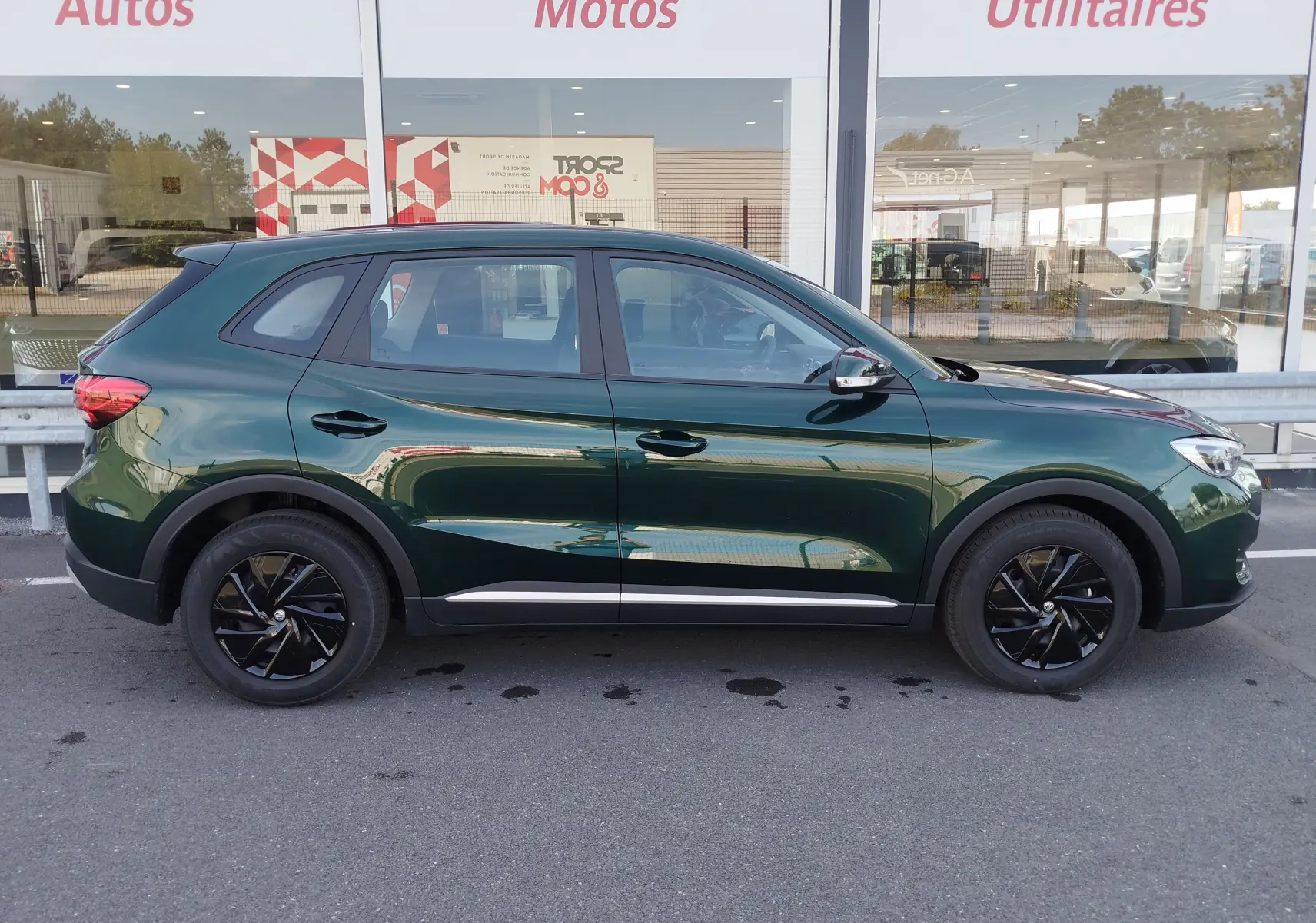 Vue de profil côté gauche d'un MG ZS 1.5L Hybrid+ 2026 en vert émeraude métallisé avec jantes noires.