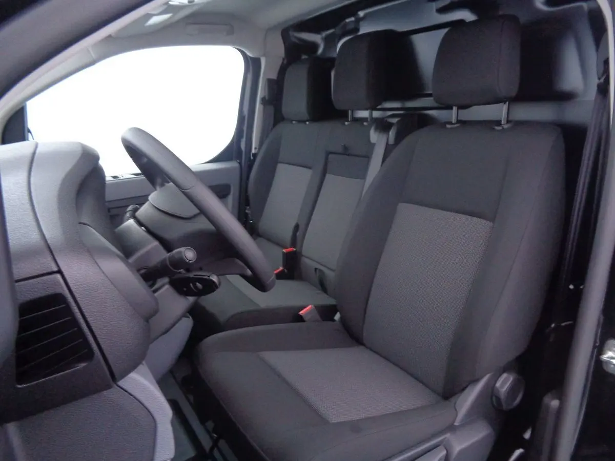 Vue intérieure côté conducteur du Peugeot Expert Fourgon 2022, sièges tissu gris et noir, volant noir visible.
