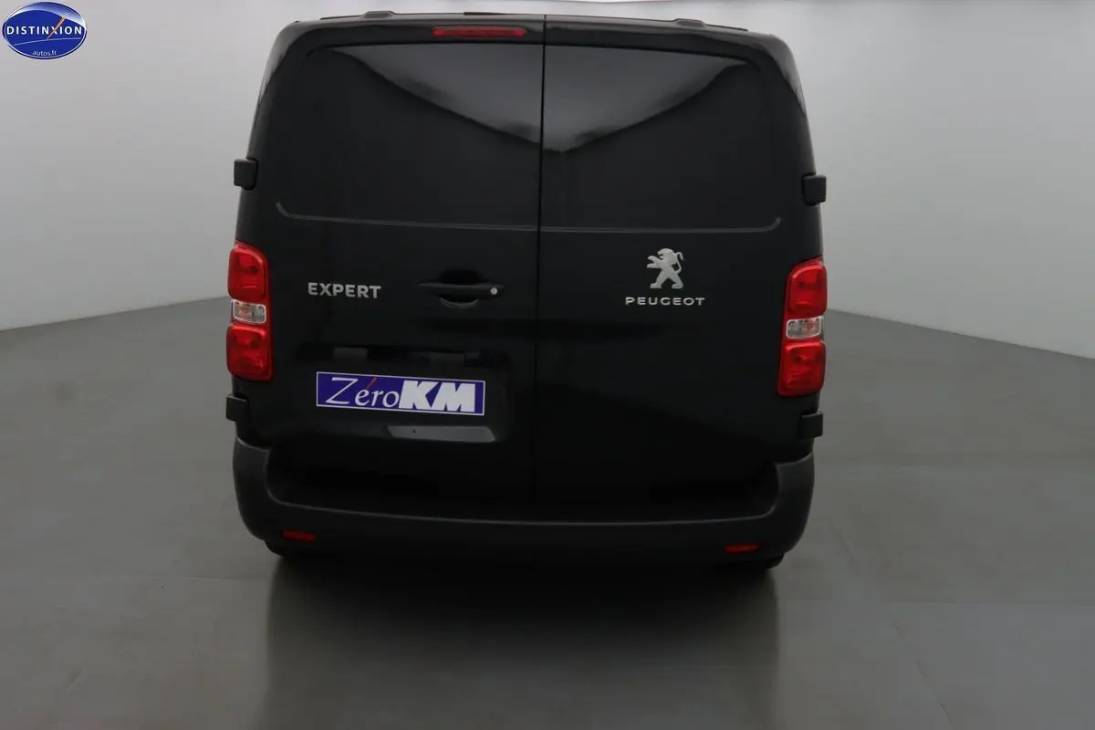 Vue arrière d’un Peugeot Expert Fourgon noir métal avec portes battantes et feux rouges visibles.