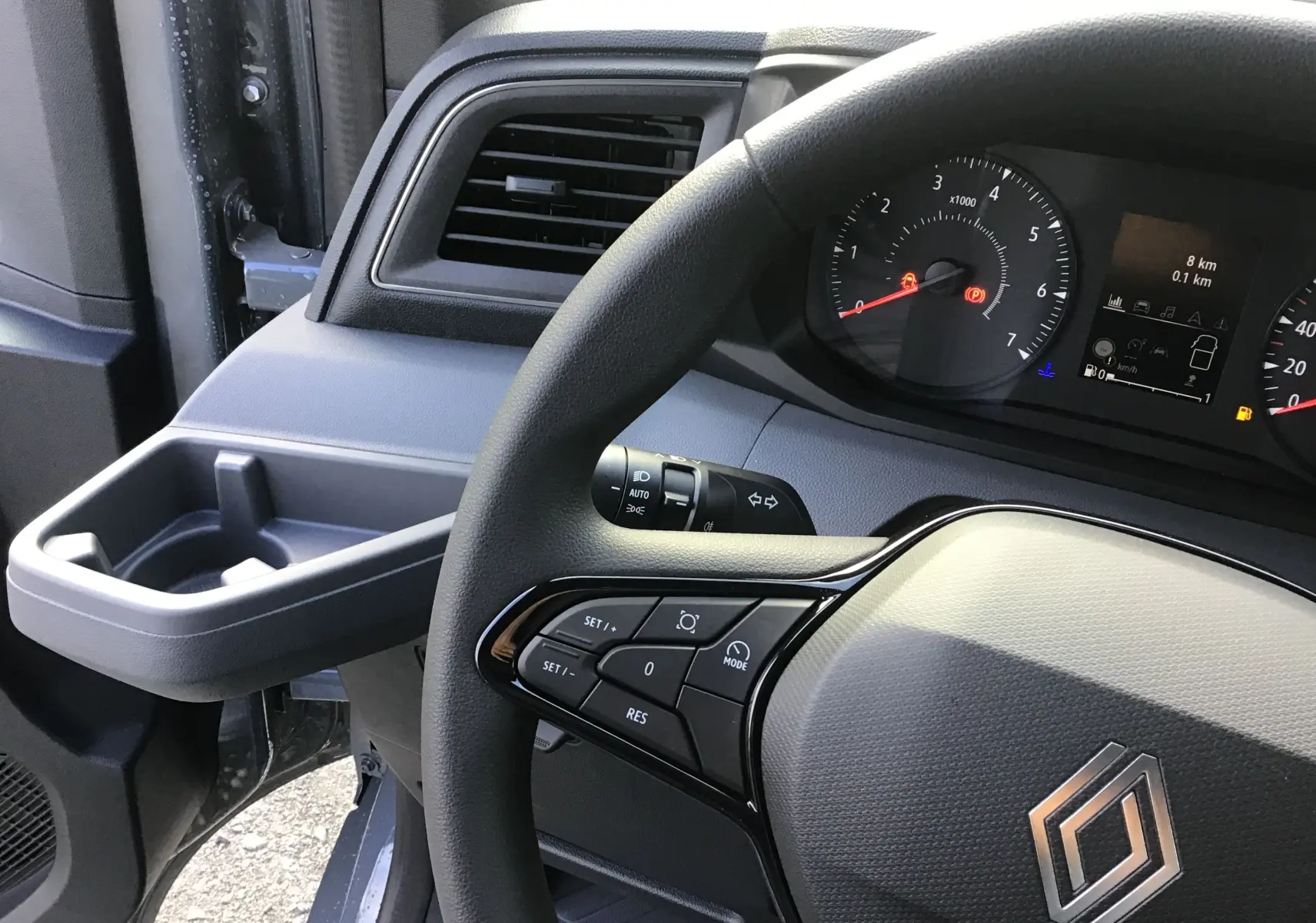 Vue intérieure rapprochée du volant et tableau de bord du Renault Master 2025, avec commandes au volant visibles.