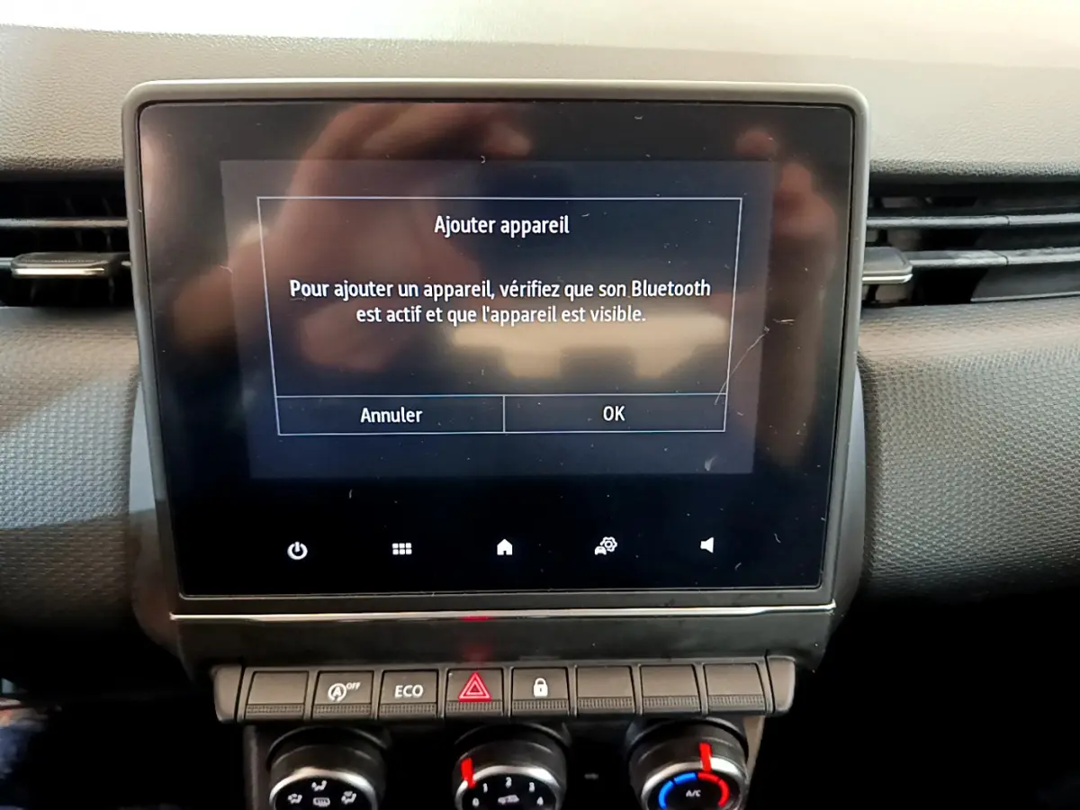 Écran tactile central affichant l'ajout d'appareil Bluetooth dans l'habitacle noir d'une Renault Clio Business 2020.