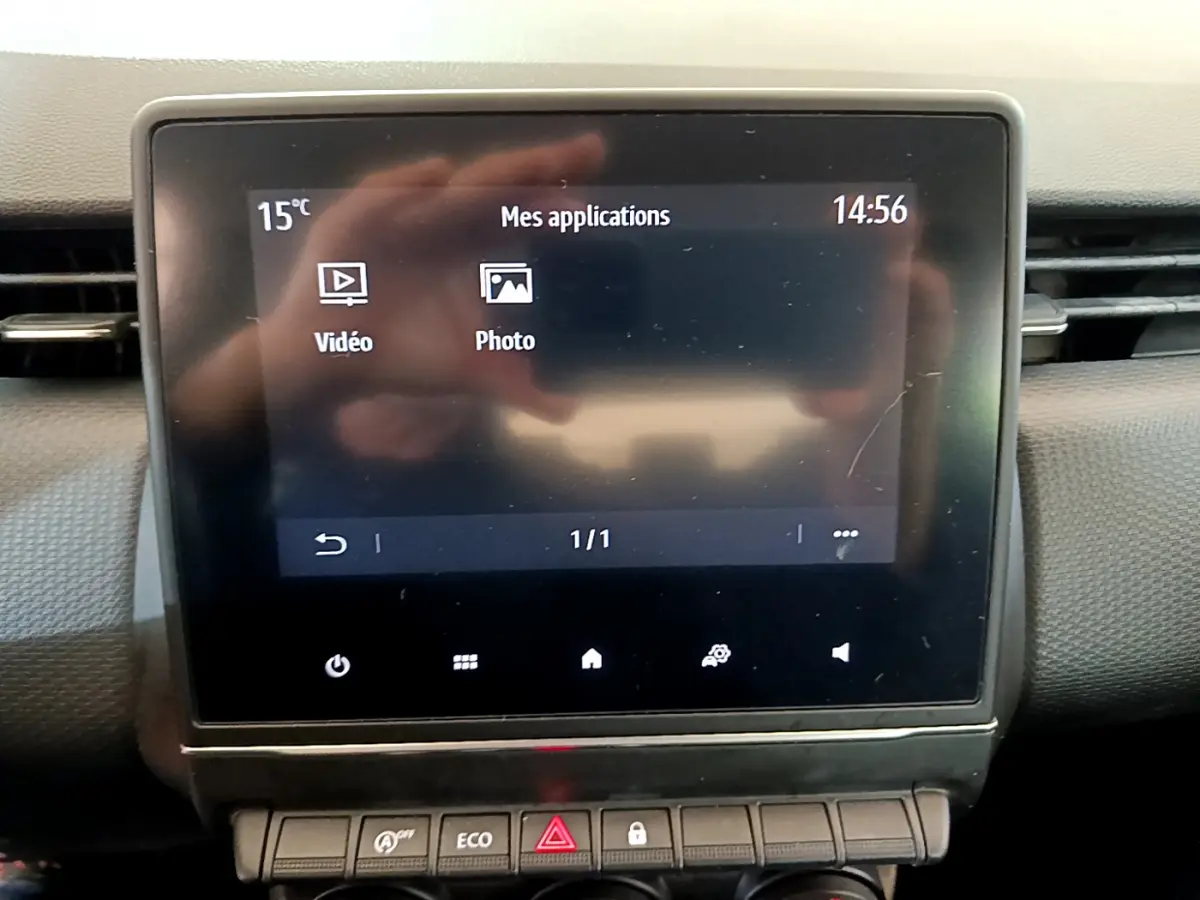 Écran tactile central affichant les applications vidéo et photo dans l’habitacle d’une Renault Clio blanche.