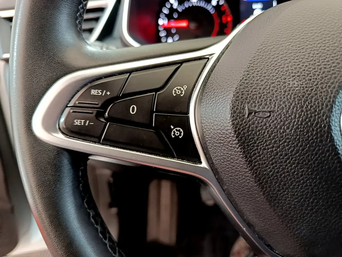 Gros plan sur le volant noir de la Renault Clio Business Blue dCi 85, avec commandes de régulateur de vitesse visibles à gauche.