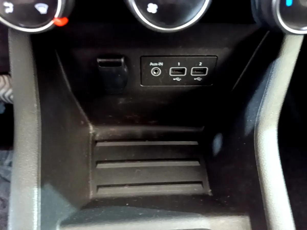 Vue rapprochée de la console centrale noire de la Renault Clio Business Blue dCi 85, avec ports USB et entrée auxiliaire visibles.