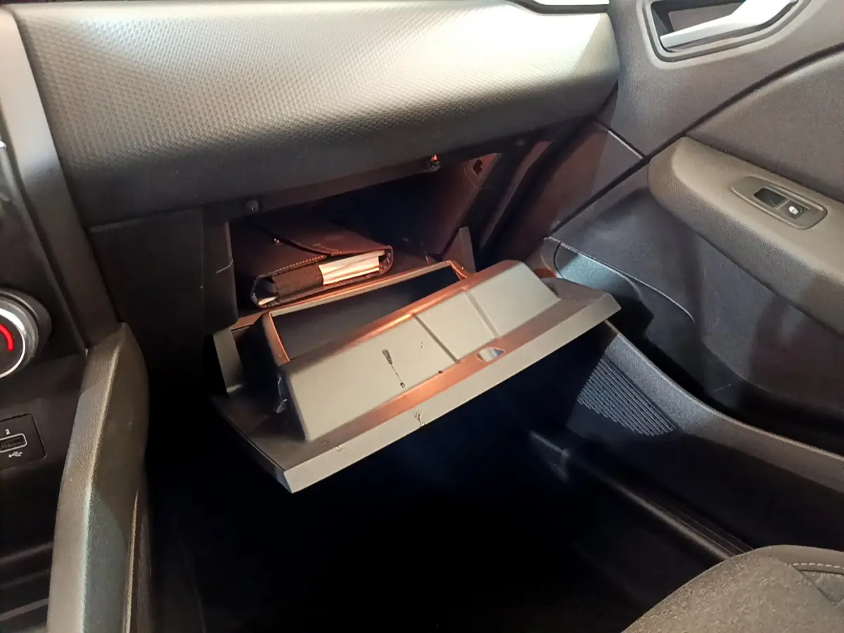 Vue intérieure côté passager de la boîte à gants ouverte dans une Renault Clio Business Blue dCi 85 noire.