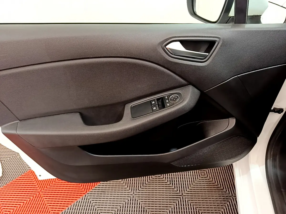 Vue intérieure côté gauche de la porte avant blanche de la Renault Clio Business avec commandes électriques des vitres.
