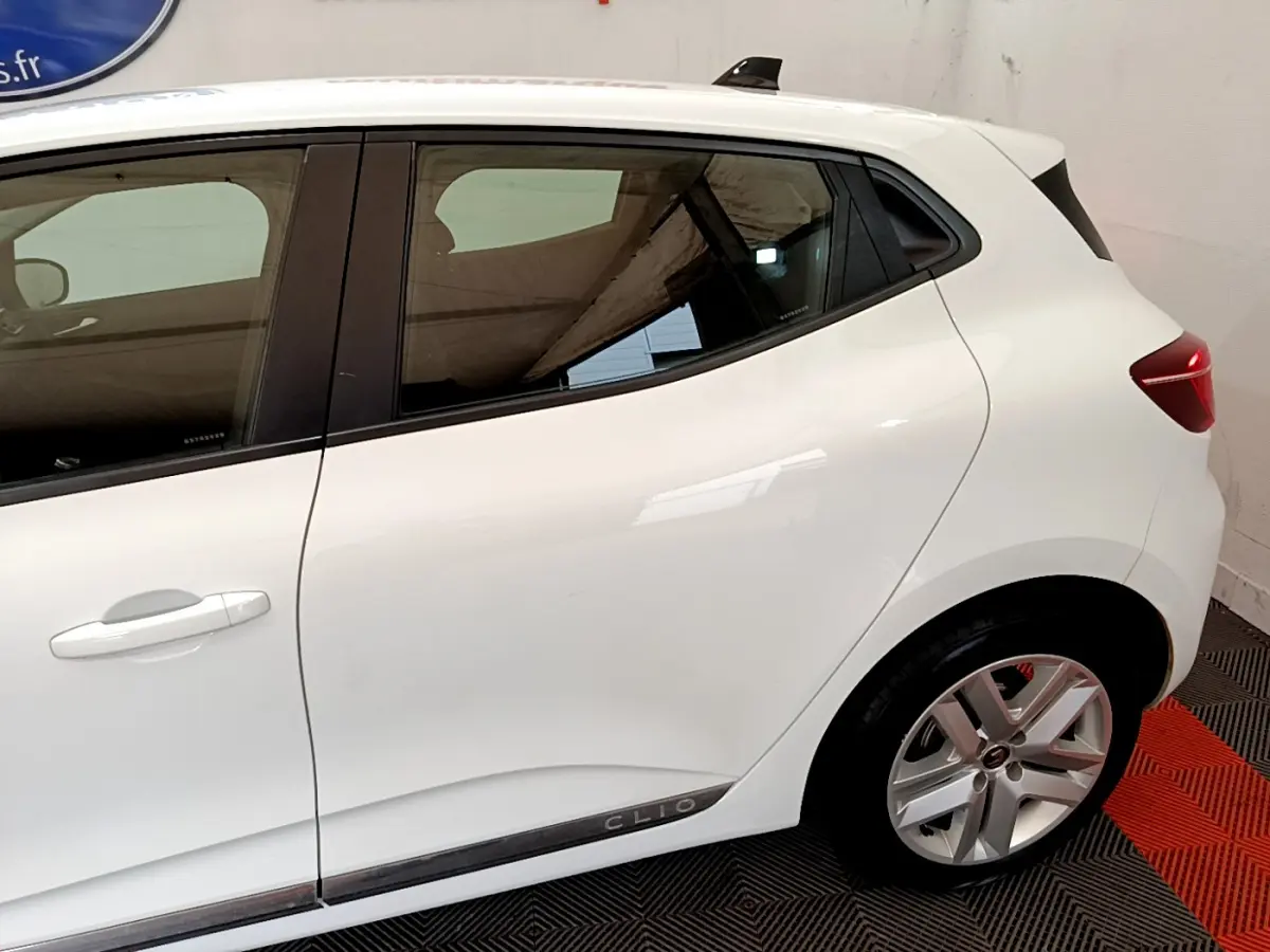 Vue latérale droite d'une Renault Clio blanche 2020 avec jantes alliage et poignées de porte intégrées.