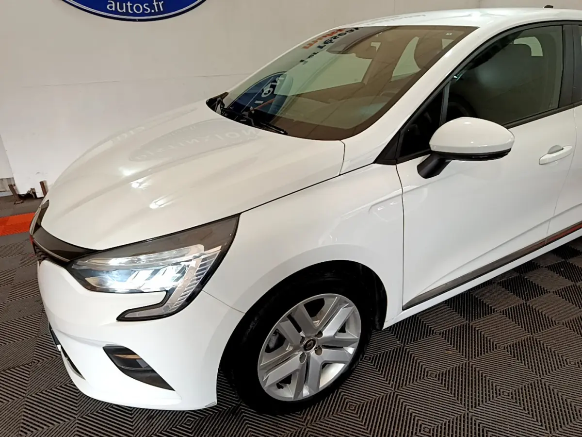 Renault Clio Business Blue dCi 85 blanche vue 3/4 avant droit avec phares LED allumés et jantes alliage.