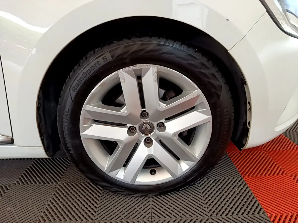 Gros plan sur la roue avant droite blanche d'une Renault Clio Business Blue dCi 85 avec jante alliage argentée.