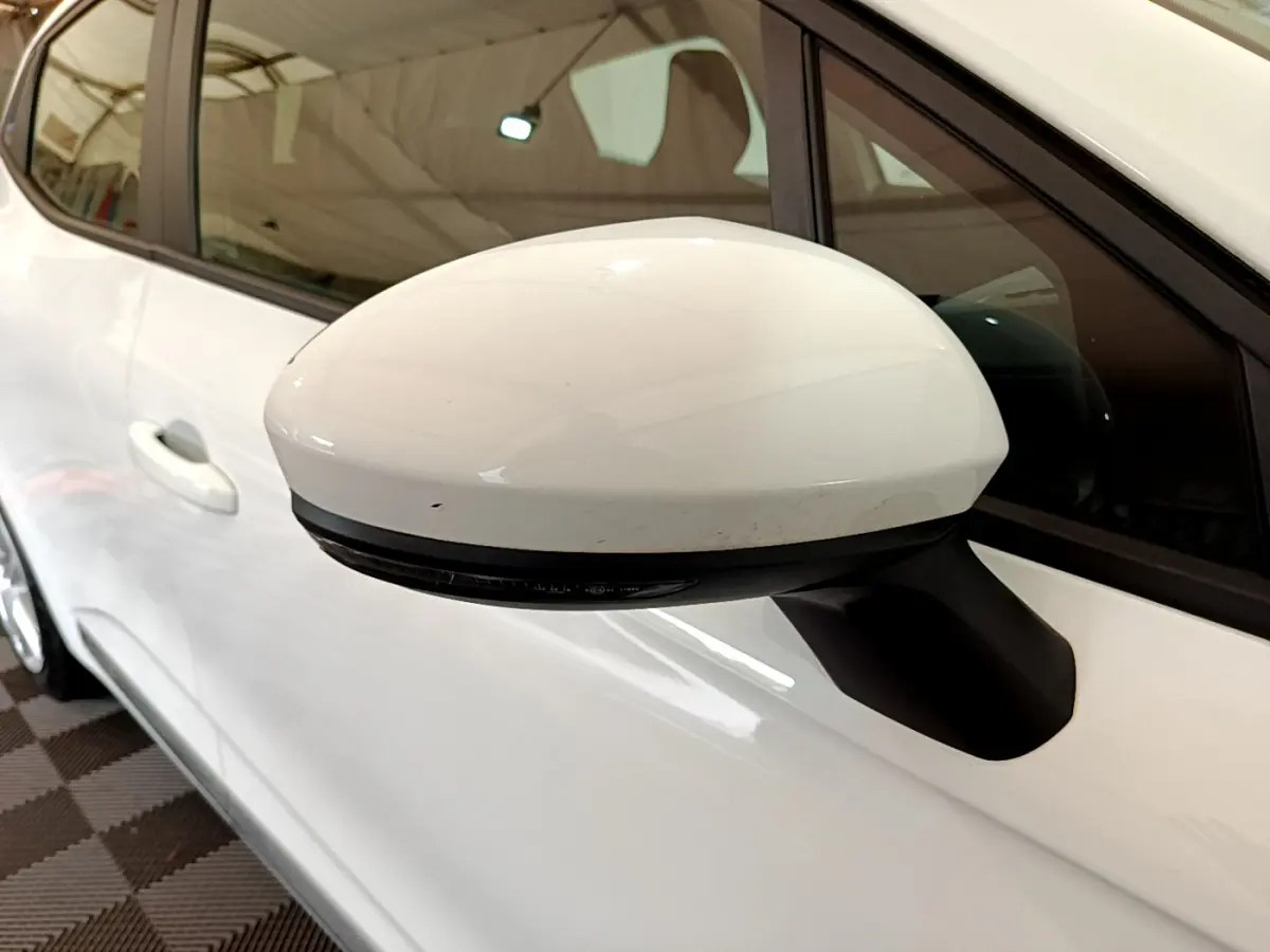 Gros plan sur le rétroviseur droit blanc d'une Renault Clio Business Blue dCi 85 2020, avec porte et vitre arrière visibles.