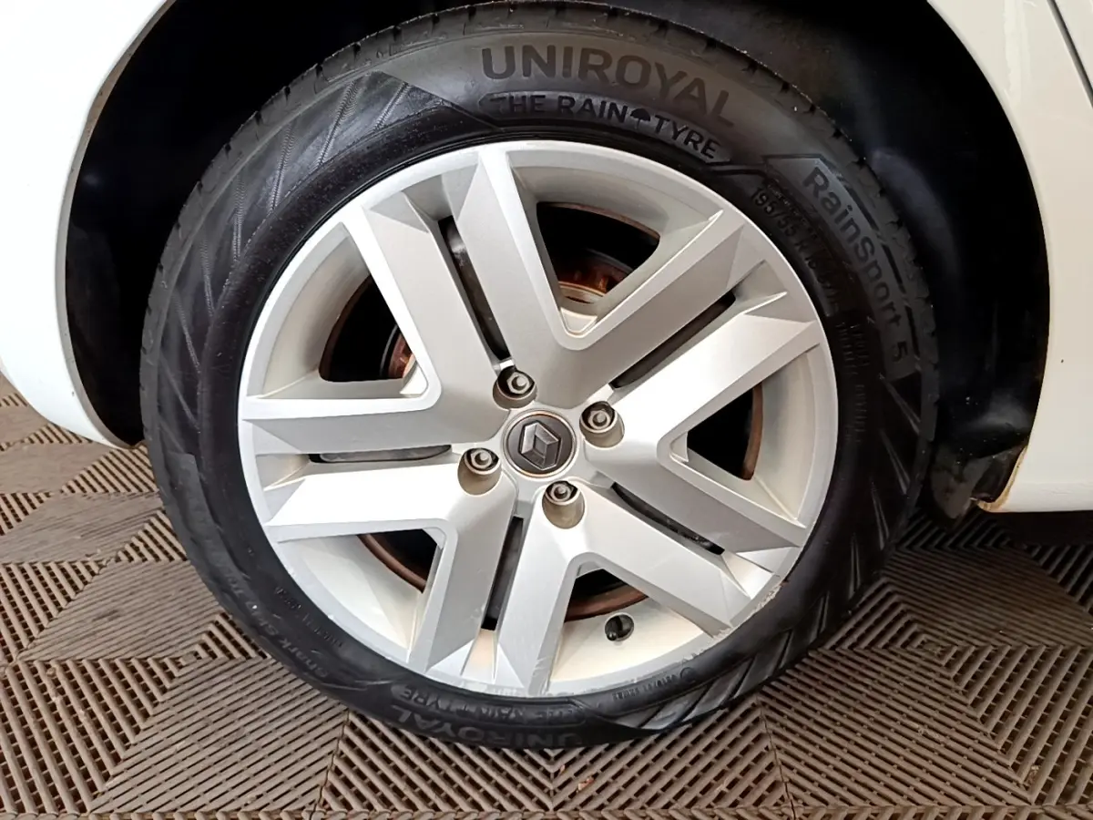 Gros plan sur la roue avant droite d'une Renault Clio blanche, avec jante alliage et pneu Uniroyal RainSport 5.