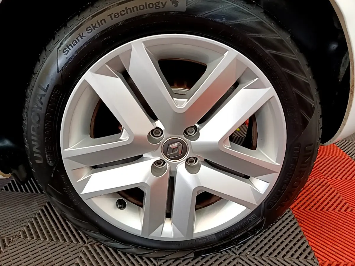 Gros plan sur la jante argentée d'une Renault Clio blanche, mettant en valeur le logo central et le pneu UniRoyal.