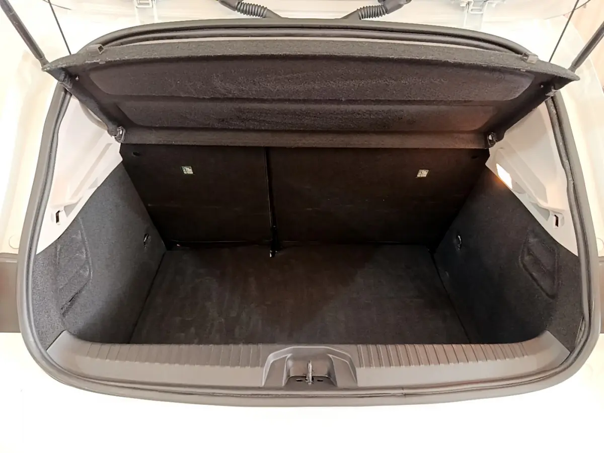 Coffre ouvert vu de l'arrière d'une Renault Clio Business Blue dCi 85 blanche, espace de chargement vide et propre.