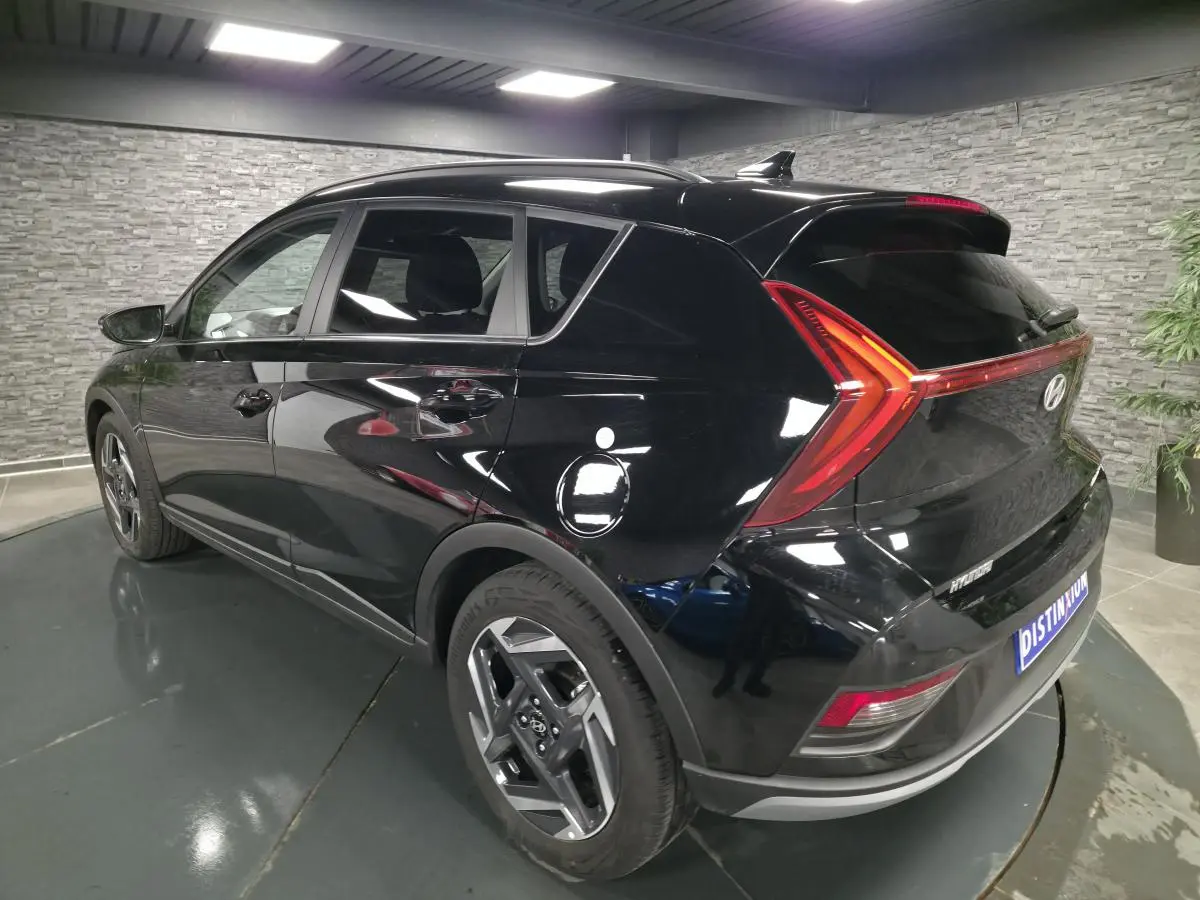 Vue 3/4 arrière côté gauche d'une Hyundai Bayon noire avec feux arrière LED en bandeau et jantes alliage 17 pouces.