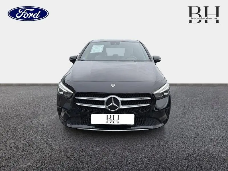 Vue avant d'une Mercedes Classe B 250 e noire cosmos métallisé avec calandre chromée et logo étoile central bien visible.