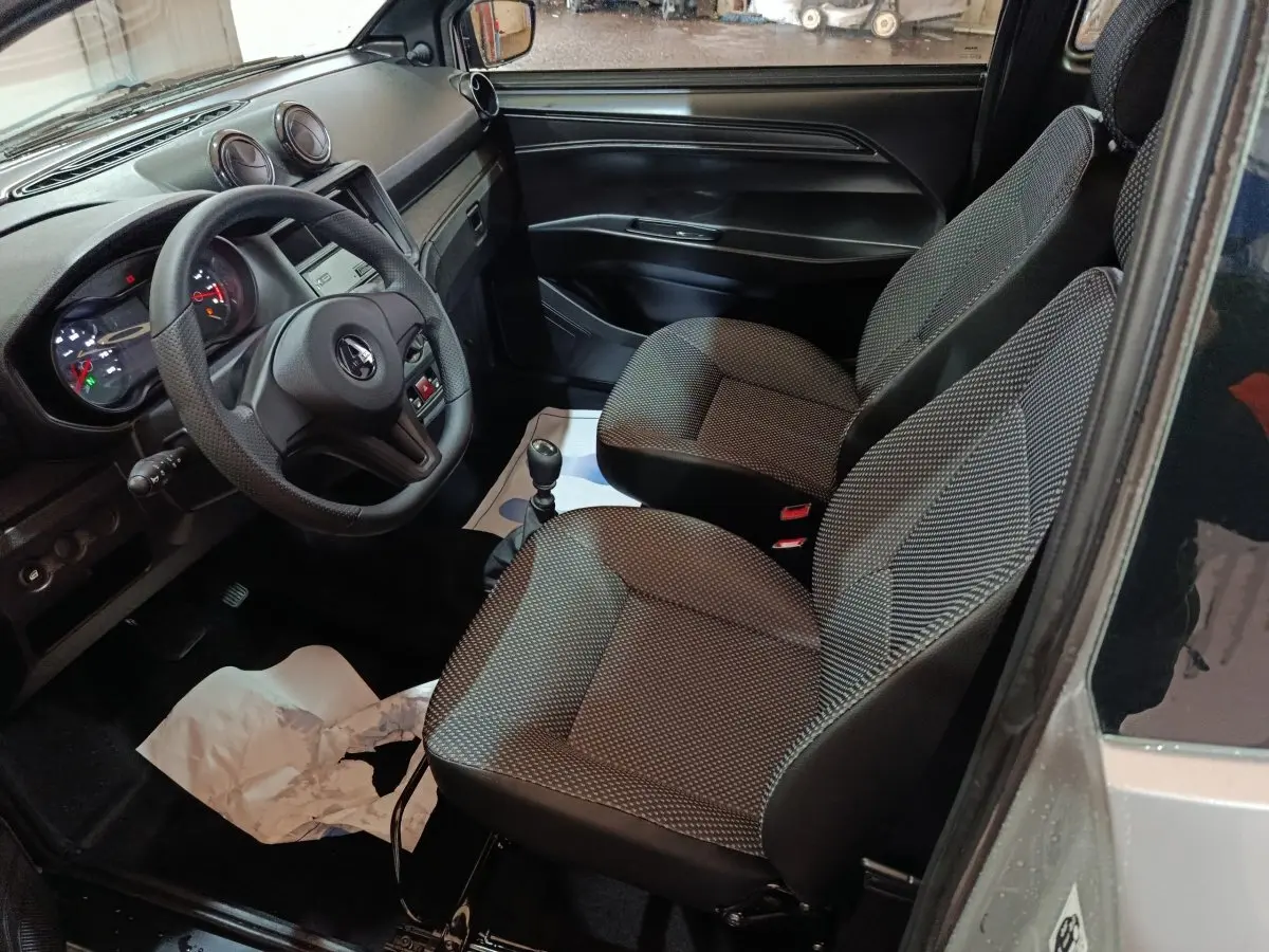 Vue intérieure côté conducteur de l'AIXAM AMBITION 0.5 CITY PACK 2026, sièges gris et tableau de bord noir.