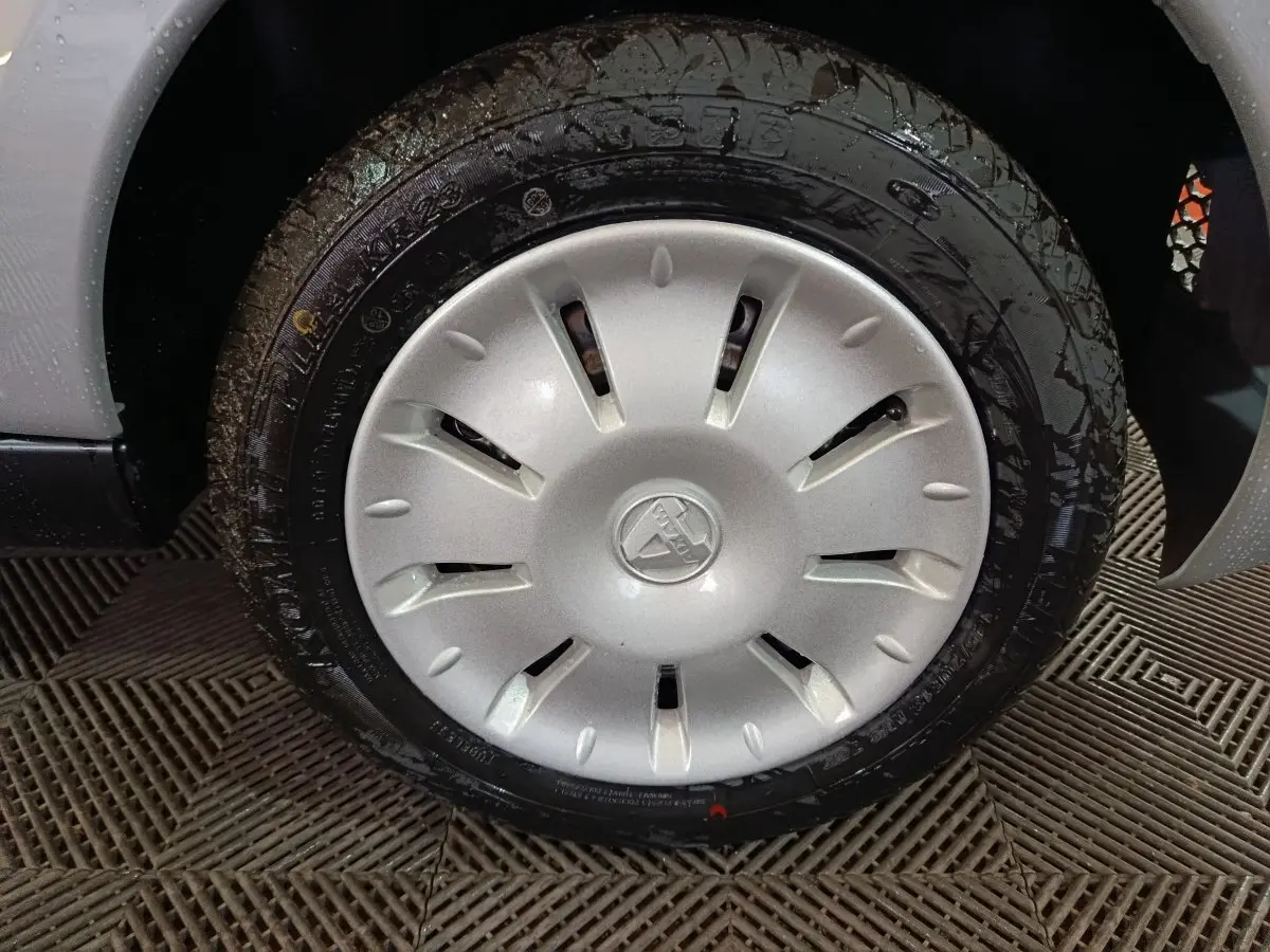 Gros plan sur la roue avant droite avec enjoliveur gris clair de l'AIXAM AMBITION 0.5 CITY PACK 2026.