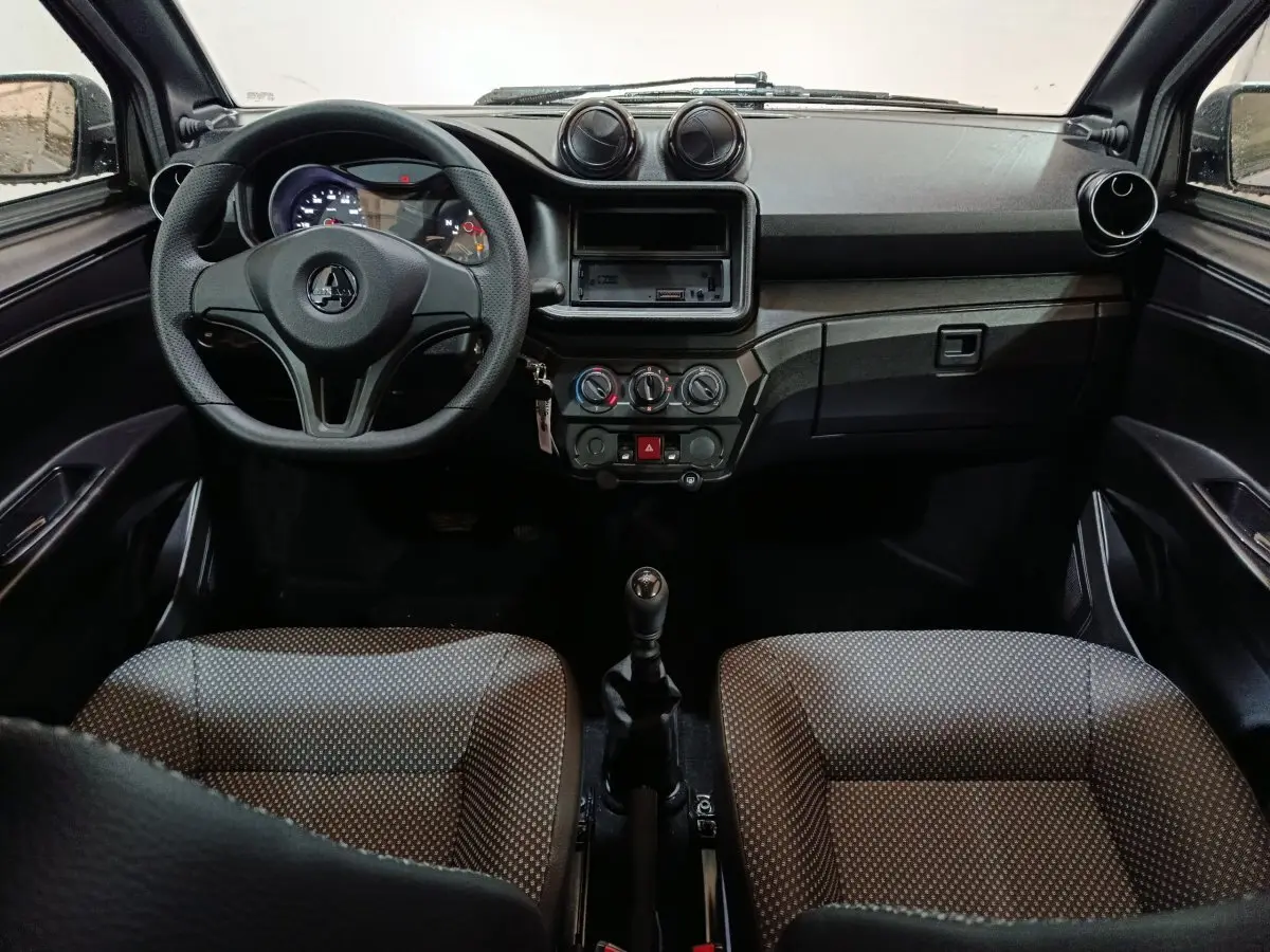 Vue intérieure frontale du tableau de bord et volant de l'AIXAM Ambition 0.5 City Pack avec sièges gris à motifs.