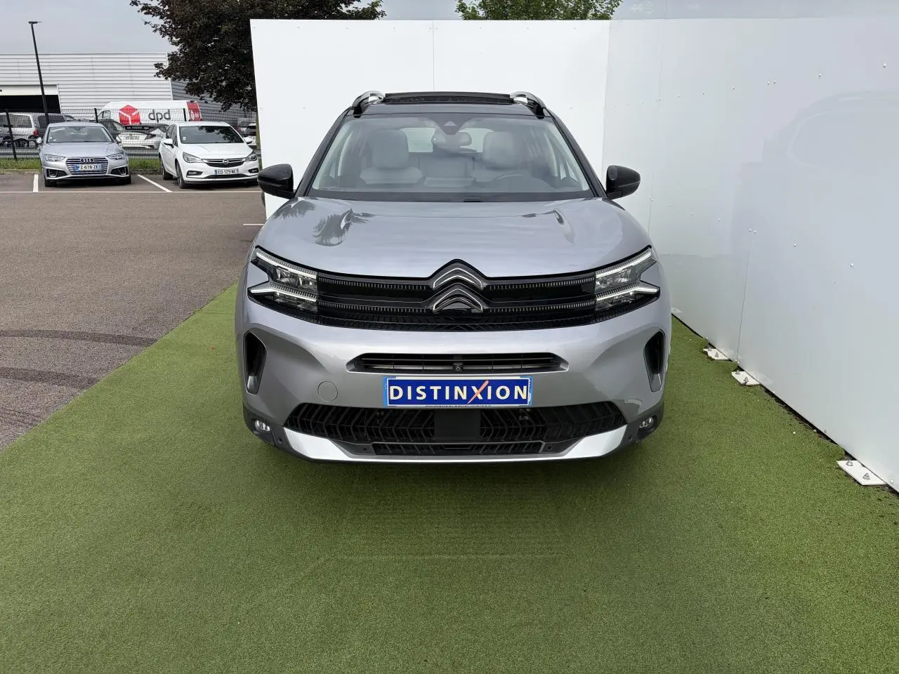 Vue avant d'un Citroën C5 Aircross gris métal avec toit panoramique et calandre noir brillant.