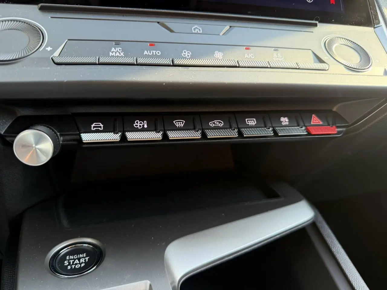 Vue rapprochée du tableau de bord de la Peugeot 308 2025, montrant les commandes climatisation et bouton start/stop.