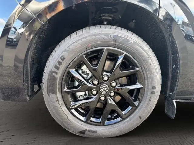 Gros plan sur la roue avant droite noire brillante d’un Volkswagen Transporter 2.0 TDi avec jante alliage noire.