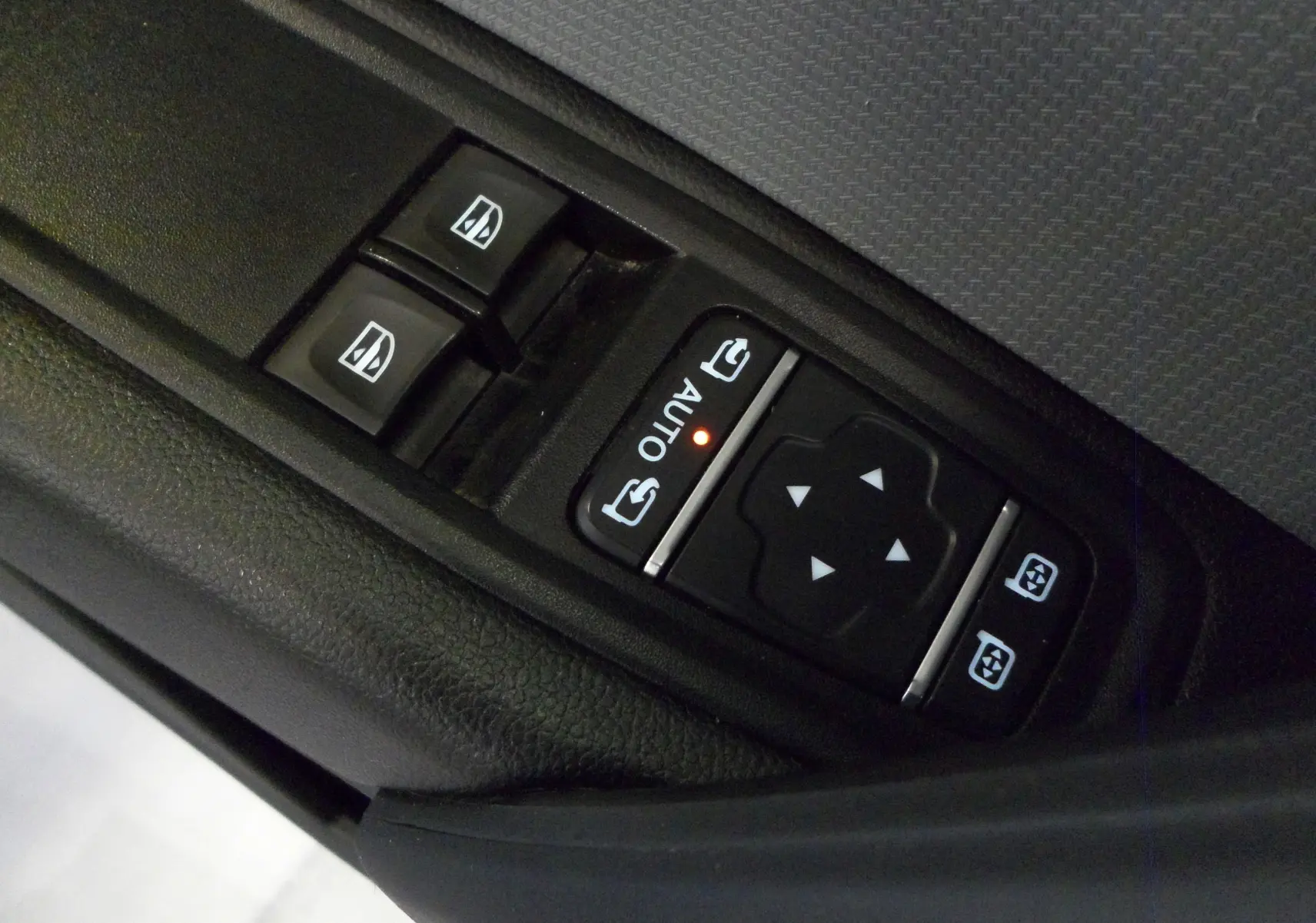 Gros plan sur les commandes de lève-vitres et réglage des rétroviseurs côté conducteur du Renault Kangoo blanc 2022.