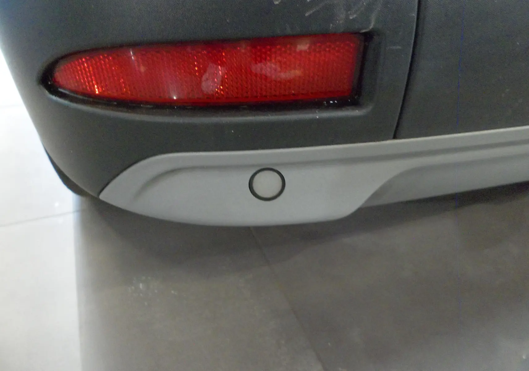 Gros plan sur le feu arrière droit et le pare-chocs gris d'un Renault Kangoo Van blanc minéral 2022.