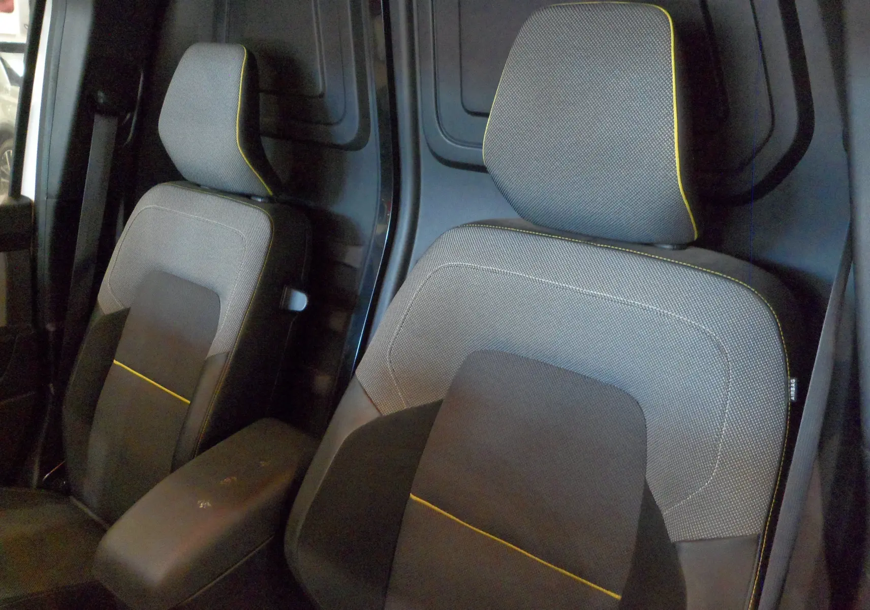 Gros plan sur les sièges avant gris avec surpiqûres jaunes du Renault Kangoo Van 2022, intérieur utilitaire.