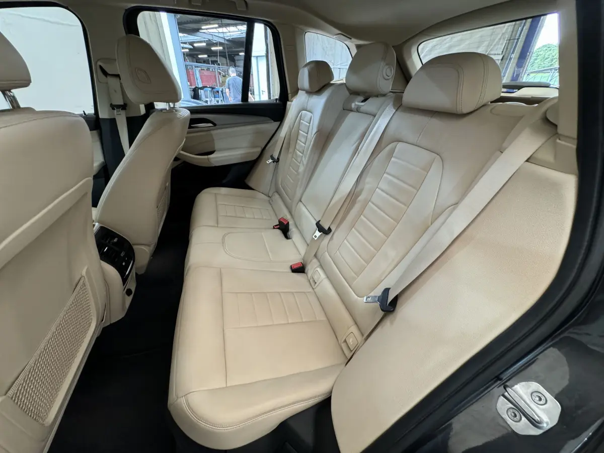 Vue intérieure côté droit des sièges arrière en cuir beige du BMW X3 xDrive30d gris foncé de 2018.