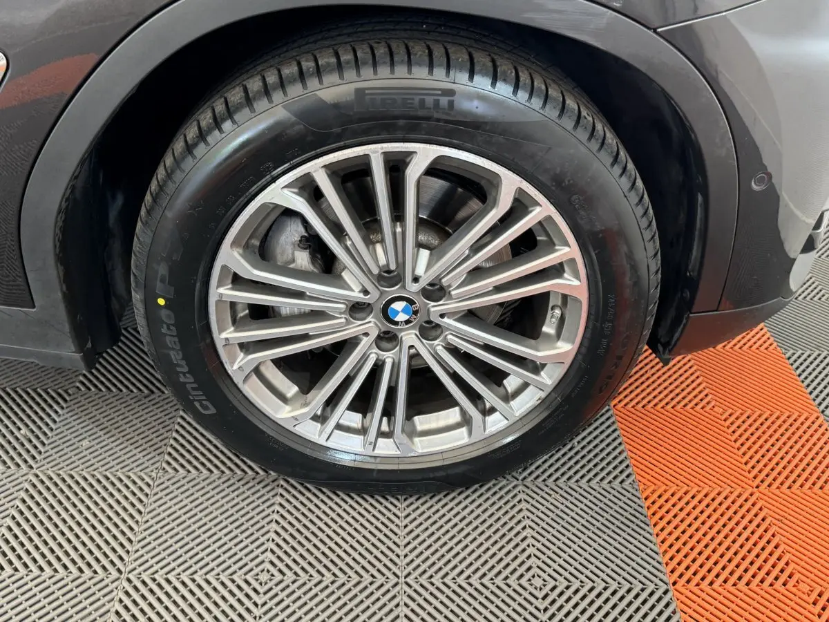 Gros plan sur la roue avant droite gris foncé d’un BMW X3 xDrive30d 2018 avec jante multibranches et pneu Pirelli.