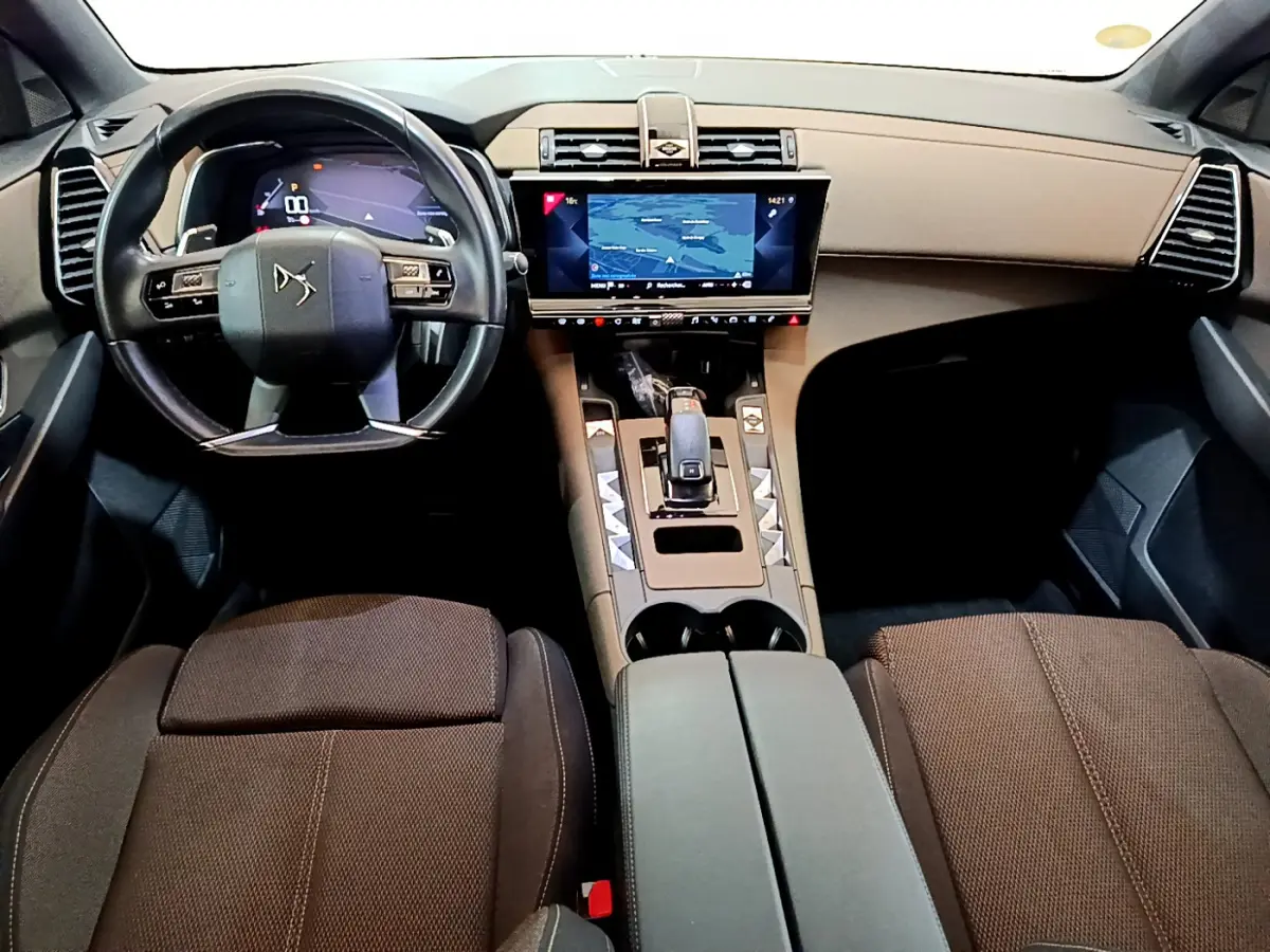 Vue intérieure avant du DS7 Crossback 2020 avec tableau de bord beige, écran tactile central et volant cuir noir.