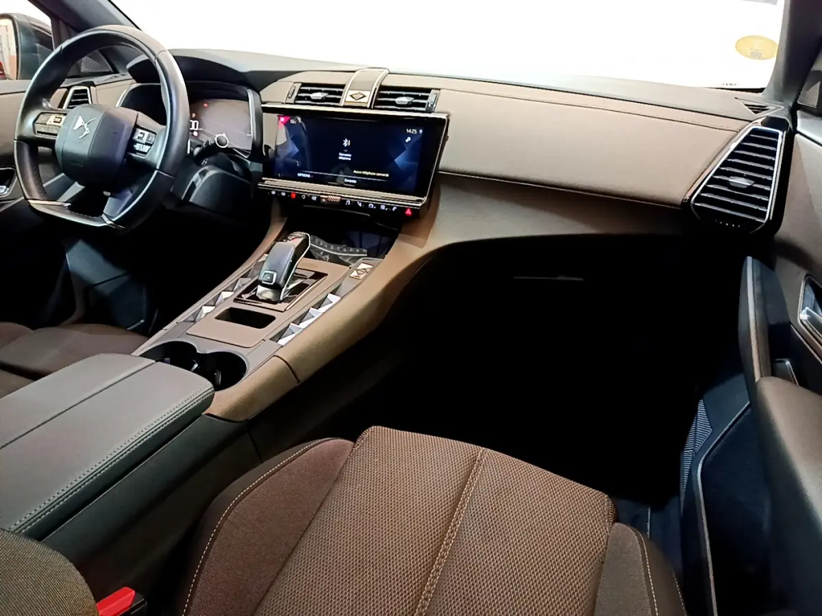 Vue intérieure côté passager du DS7 Crossback 2020, tableau de bord et console centrale en tons marron et noir.