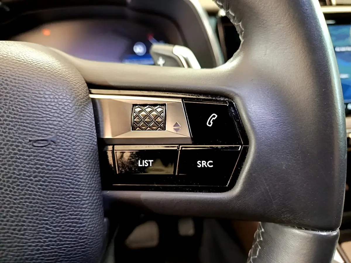 Gros plan sur les commandes gauche du volant cuir noir du DS7 Crossback 2020, boutons LIST, SRC et téléphone.