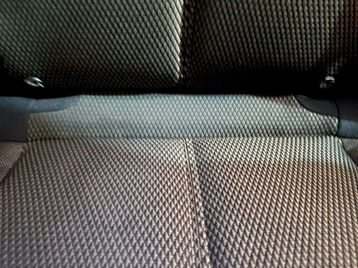 Gros plan sur la texture du tissu gris foncé de la banquette arrière du DS7 Crossback, vue de dessus.